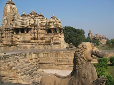 Tempelcomplex van Khajuraho met leeuwenbeeld en trappen in de voorgrond.
