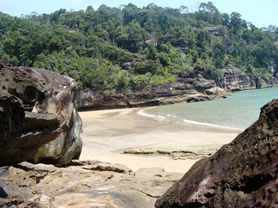 Rotsachtige baai met zandstrand en regenwoudkust op Maleisisch Borneo tijdens de route Hoogtepunten.