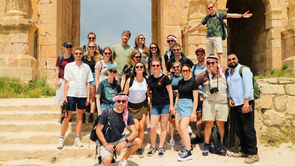Groep 22-35ers reizigers bij Romeinse ruïnes in Jordanië tijdens groepsrondreis.