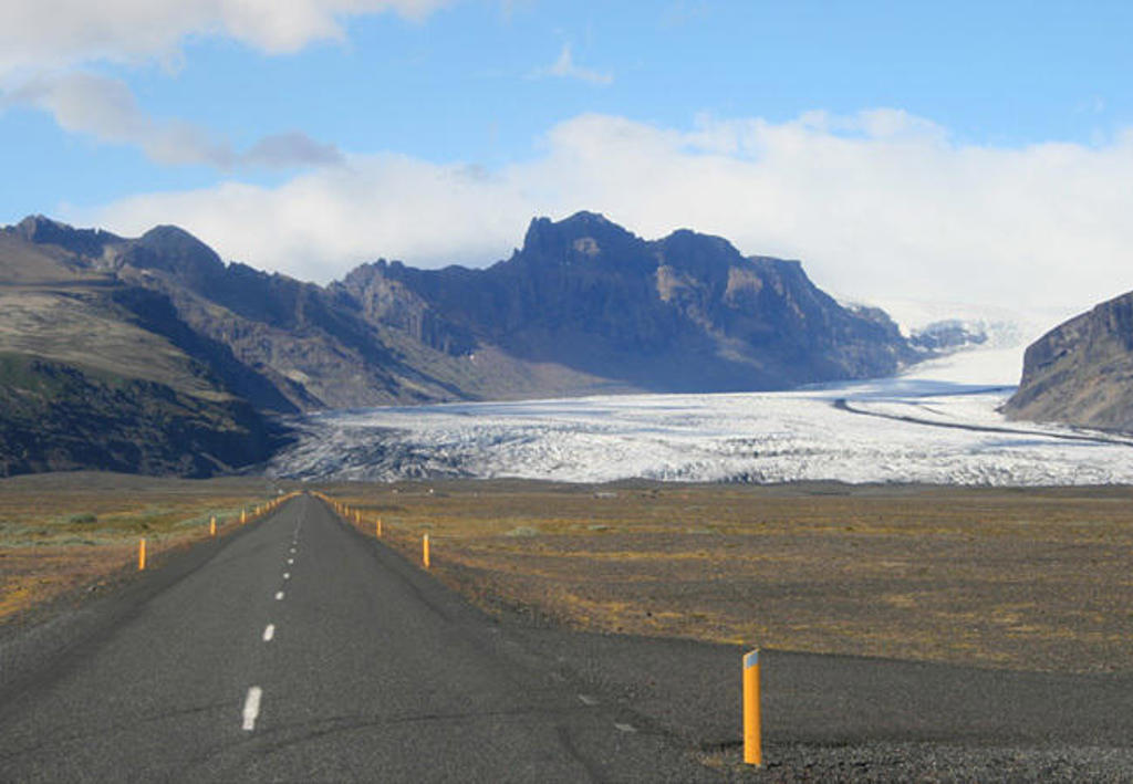 Weg door het IJslandse landschap richting een gletsjer en bergen, tijdens een familiereis IJsland.
