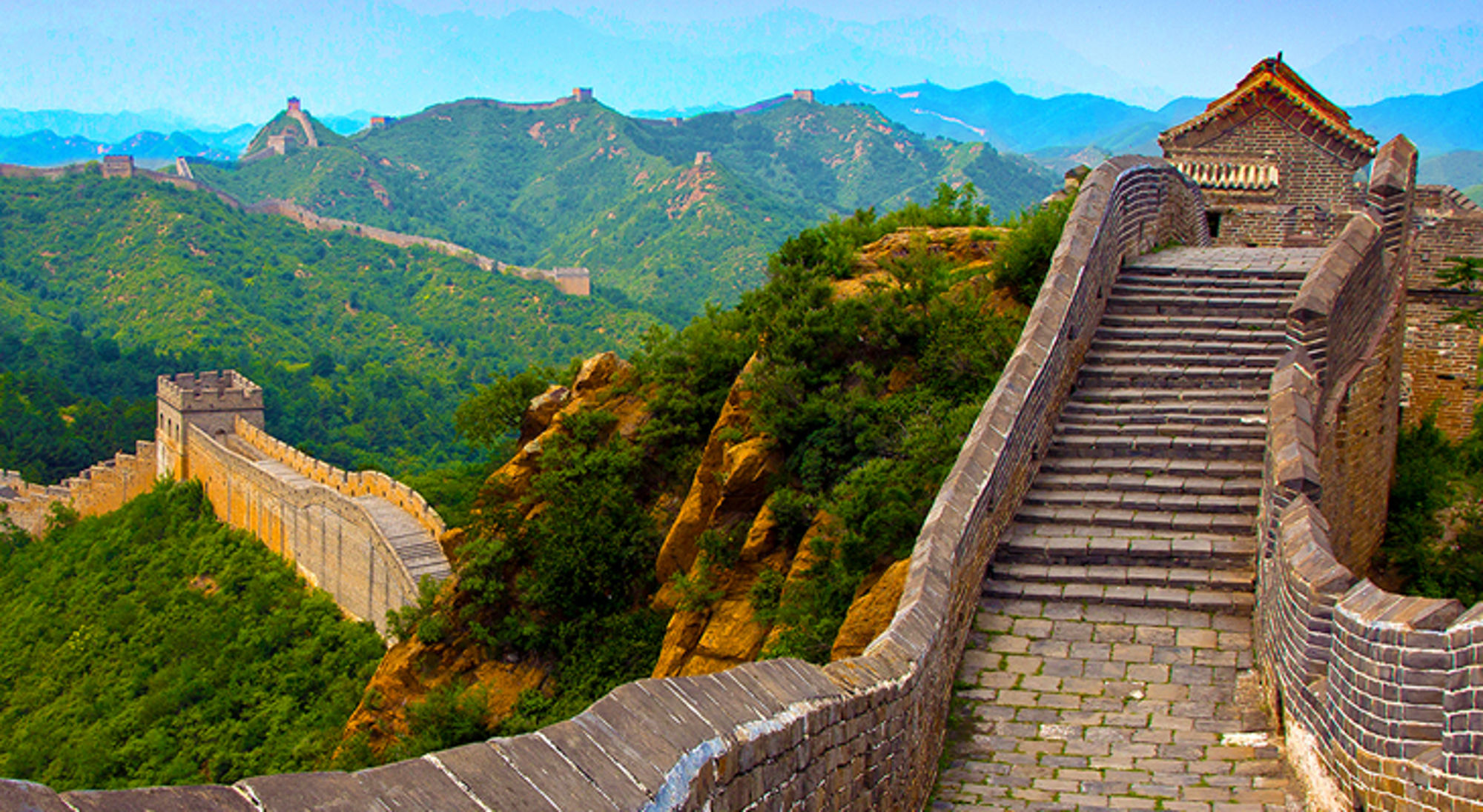 De Chinese Muur slingert over groene bergkammen, met stenen trappen en wachttorens op de voorgrond.