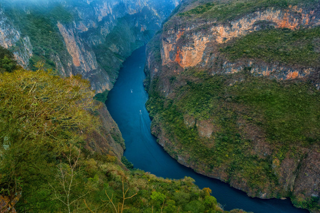 Diepe kloof met kronkelende rivier tussen steile rotswanden in Mexico, tijdens een familiereis.