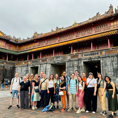 Groepsfoto van 22-35ers tijdens rondreis Vietnam bij de Keizerlijke Stad in Hué.