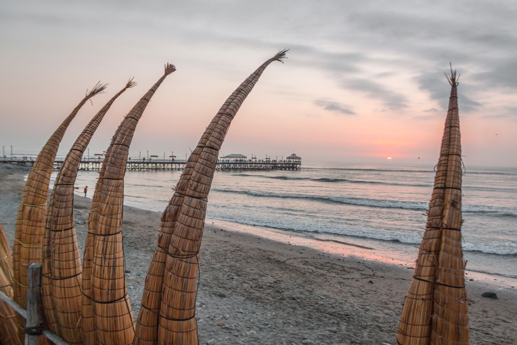 Rieten vissersboten op het strand van Huanchaco bij zonsondergang, Noord-Peru.