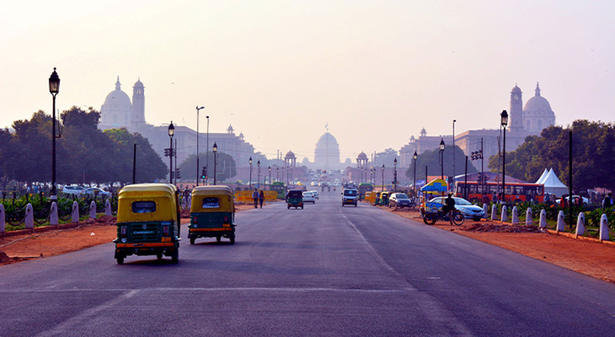 Delhi India Drukke boulevard in New Delhi met riksja’s en uitzicht op India Gate en regeringsgebouwen in de verte.