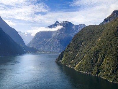 Uitzicht over Milford Sound met steile bergen en fjordwater op de Route Nieuw-Zeeland.
