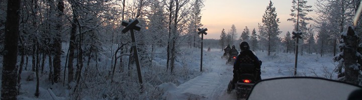 Sneeuwscootertocht door besneeuwd bos in Finland tijdens een winterrondreis.