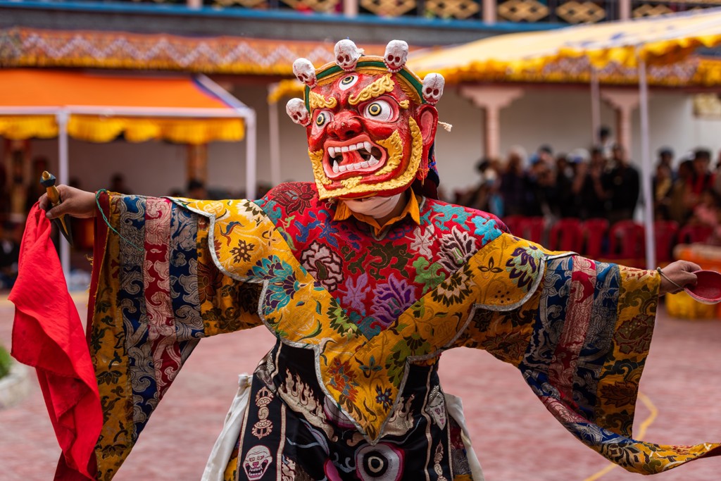 Gemaskerde danser in kleurrijk kostuum tijdens een Ladakh kloosterfestival in India.