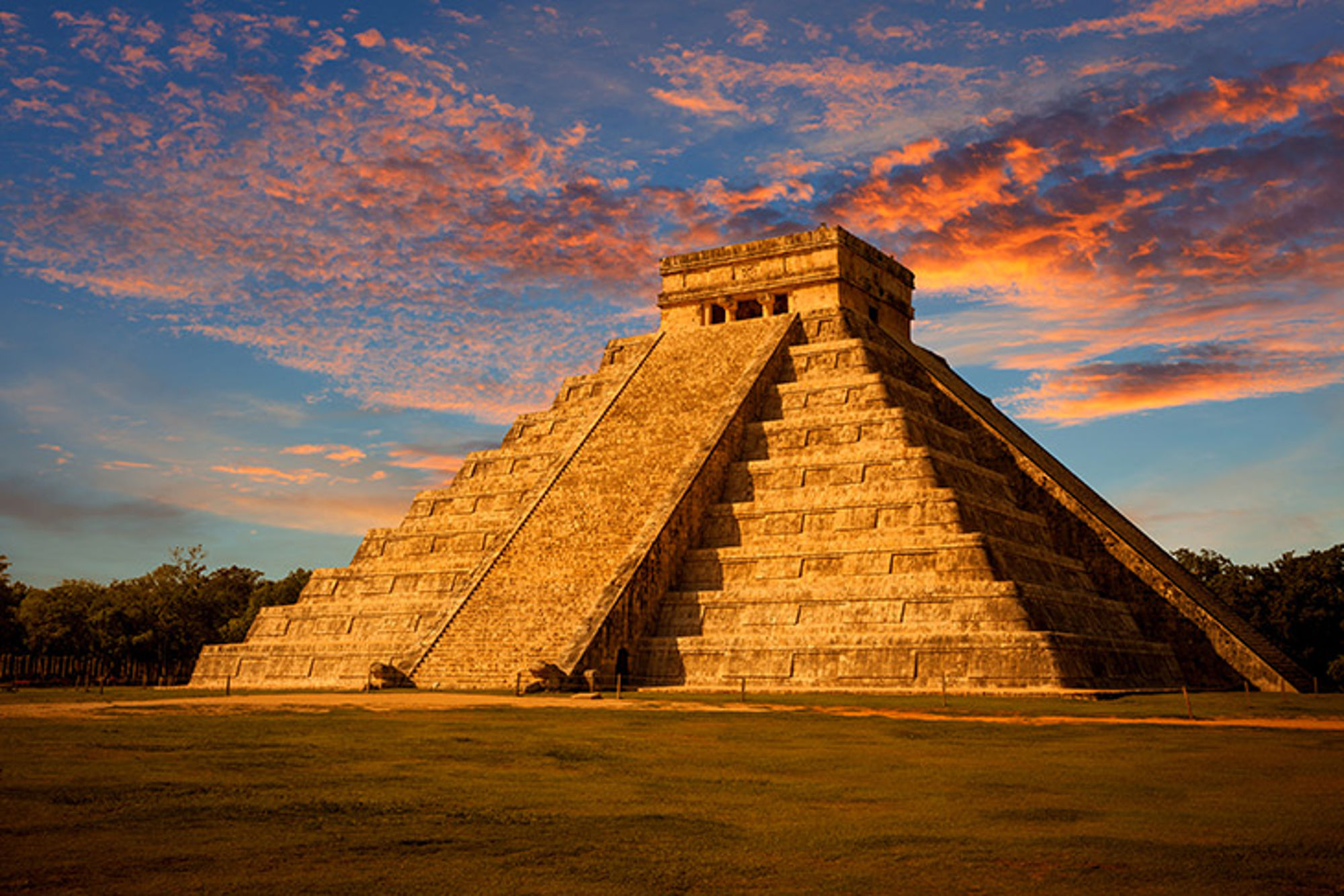 Chichén Itzá, Mexico Piramide El Castillo in Chichén Itzá bij zonsondergang onder een kleurrijke wolkenlucht.