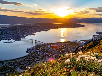 Zonsondergang boven Tromsø met uitzicht op fjord en brug, tijdens de zeilreis Noord Noorwegen.