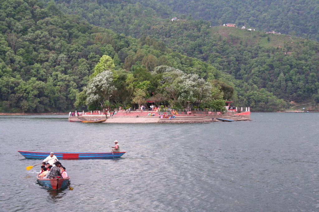 Boottocht over Phewa Lake bij Pokhara, met tempel op een eiland en groene heuvels op de achtergrond.