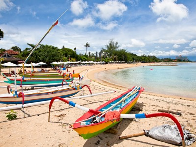 Kleurrijke traditionele boten op het strand van Bali langs een rustige baai.