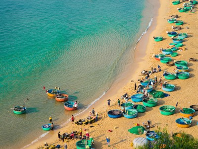 Vissersboten en ronde mandboten op het strand aan de kust van Vietnam tijdens Route Vietnam dag 6.