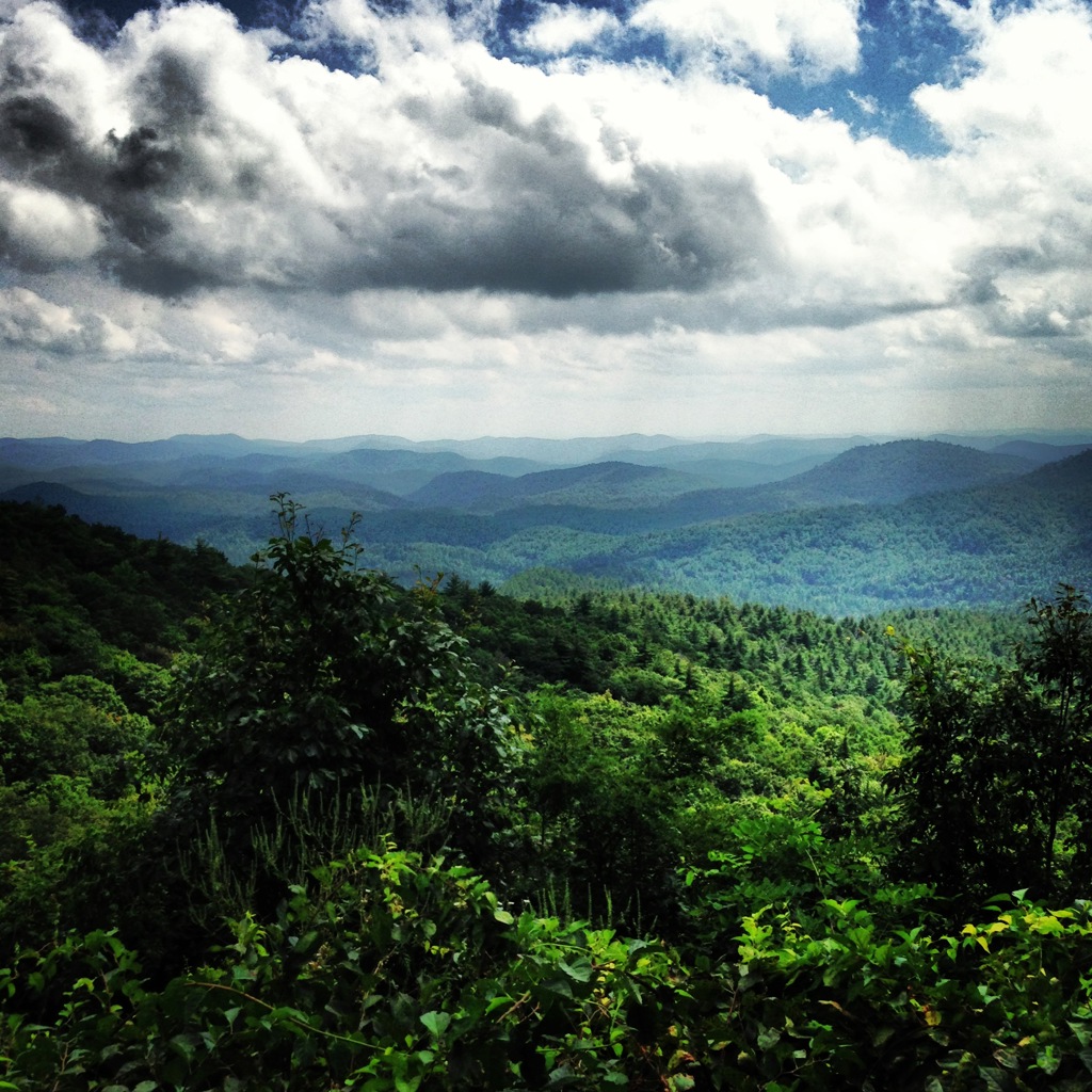 Uitzicht over de groene Blue Ridge Mountains onder een dramatische wolkenlucht tijdens een groepsrondreis door de VS.
