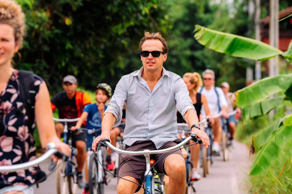 Gezin fietst door groen landschap tijdens familiereis Thailand Hoogtepunten.
