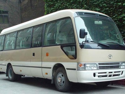 Beige minibus in Tibet, gebruikt voor vervoer tijdens reizen.