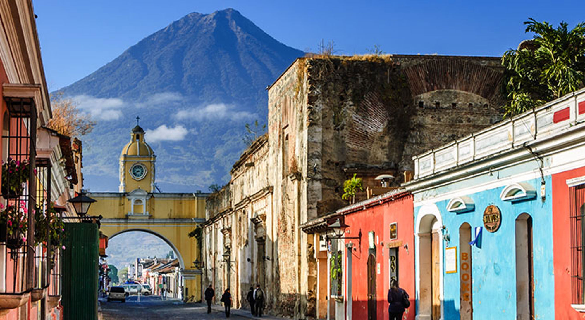 De mooiste stad ter wereld Antigua Straat in Antigua Guatemala met de Santa Catalina-boog en vulkaan Agua op de achtergrond.
