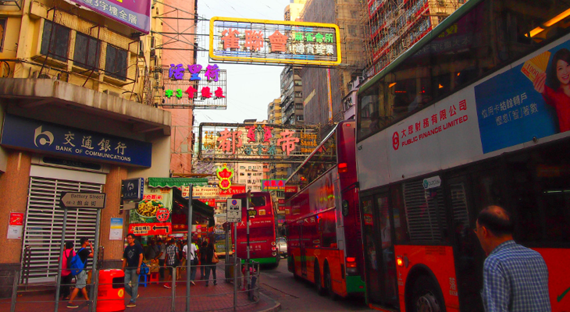 Hong Kong in China Drukke straat in Hongkong met dubbeldekkerbussen, voetgangers en kleurrijke neonreclames in Chinese tekens.