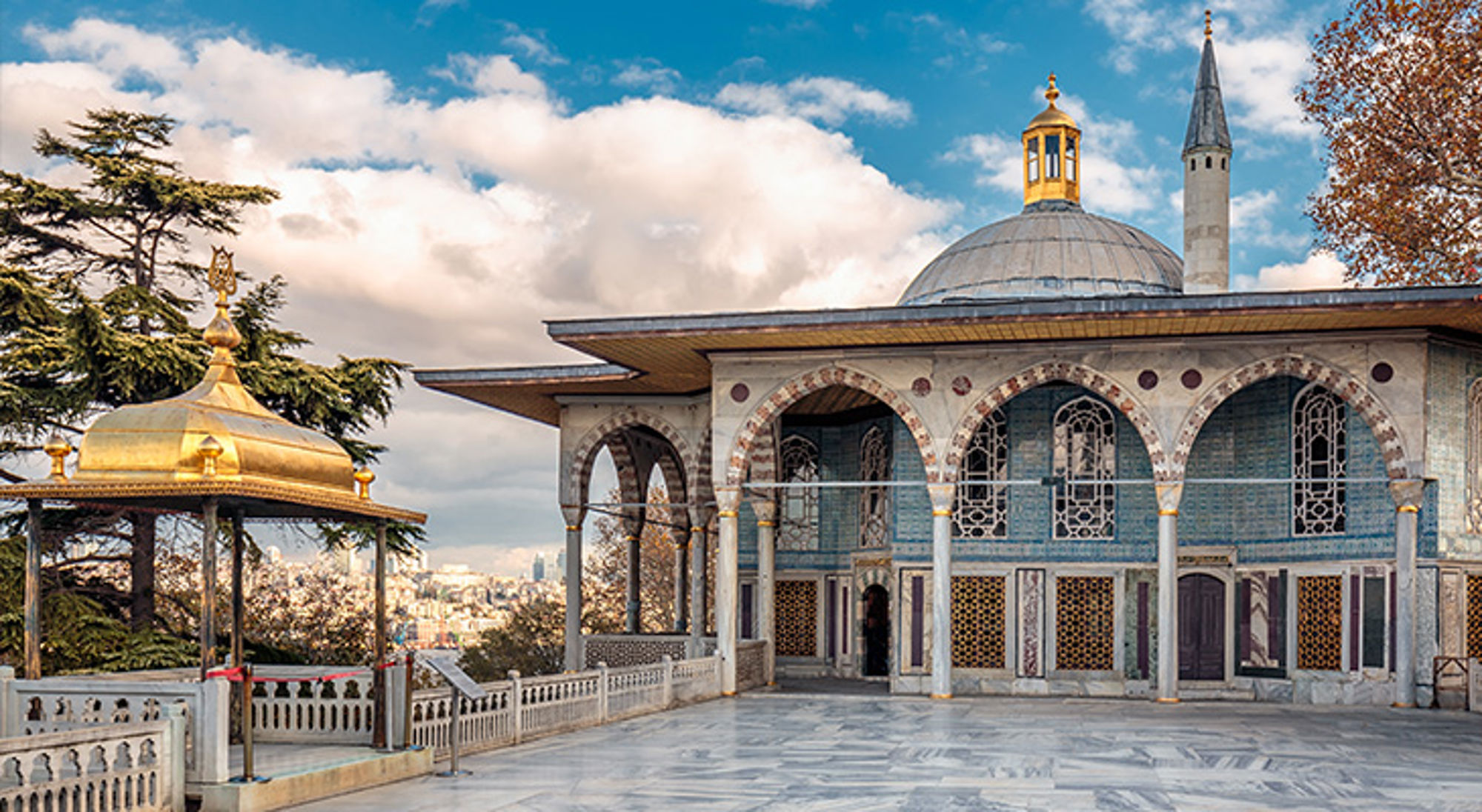 Topkapi Palace Istanbul Uitzicht op het Topkapi-paleis in Istanbul met koepel, minaret en gouden paviljoen onder een blauwe lucht.