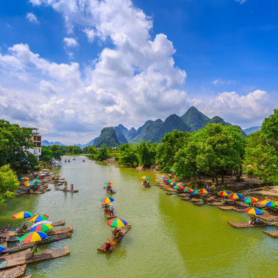 Bamboevlotten met kleurrijke parasols op de Li-rivier bij Guilin, tijdens een groepsrondreis China.