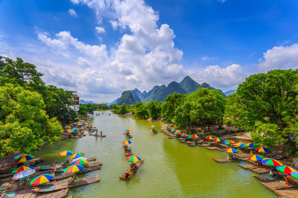 Bamboevlotten met kleurrijke parasols op de Li-rivier bij Guilin, tijdens een groepsrondreis China.