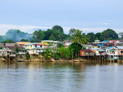 Kleurrijke paalwoningen langs een rivier in Borneo, Maleisië.