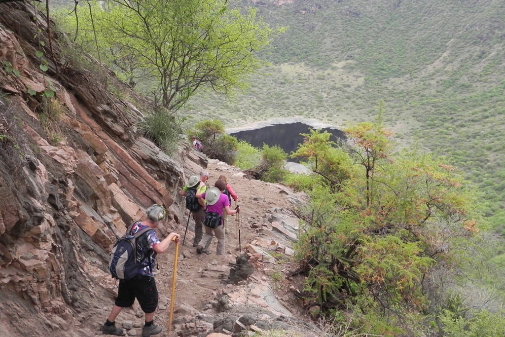 Wandelaars op smal bergpad langs rotswand tijdens groepsrondreis Ethiopië.