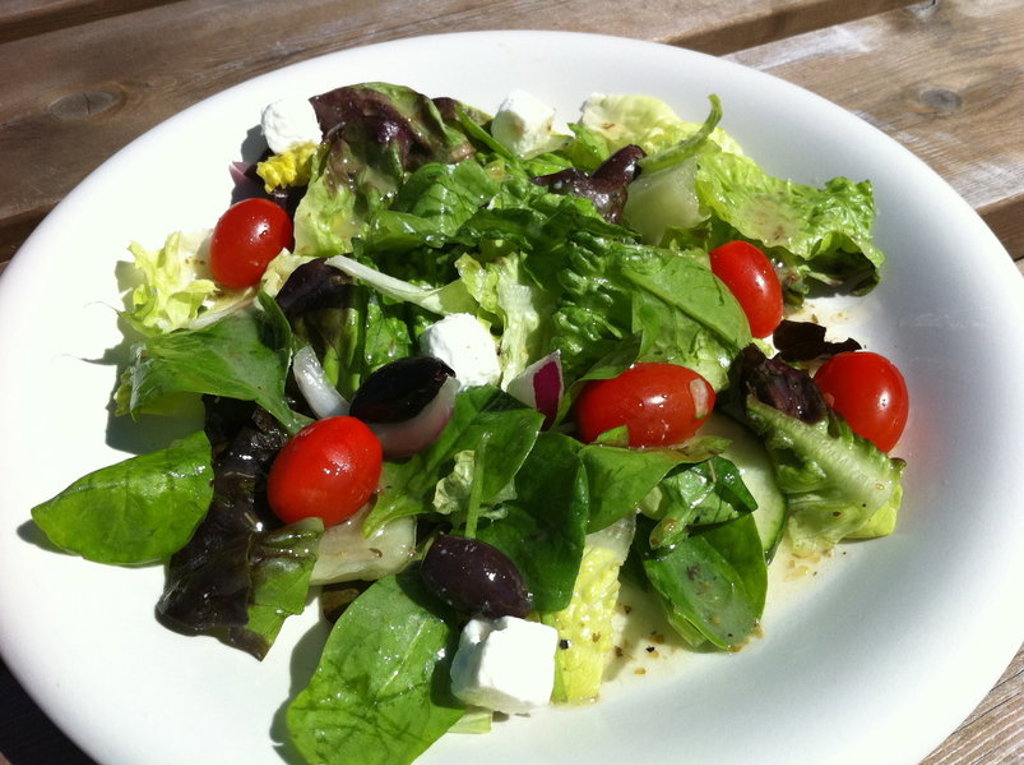 Griekse salade met sla, cherrytomaten, olijven en feta op Naxos, Santorini en Paros.
