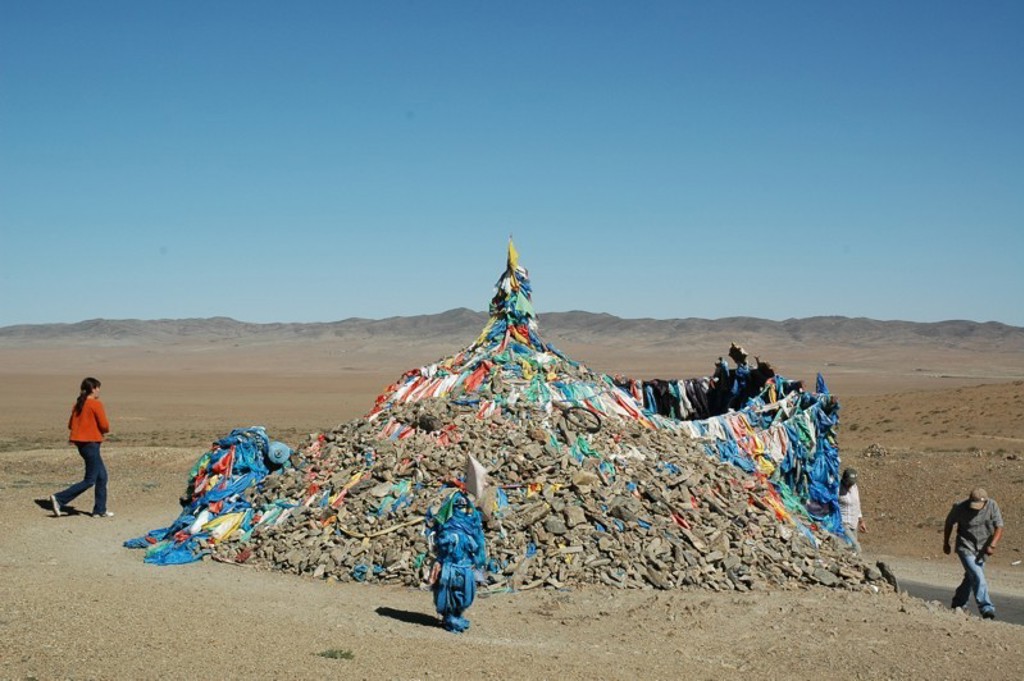 Ovoo met kleurrijke gebedsvlaggen in de Mongoolse steppe tijdens een groepsrondreis Mongolië.