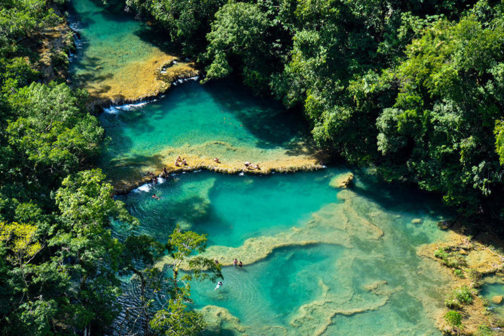 Turquoise rivierpoelen in het regenwoud van Guatemala, gezien van boven tijdens een groepsrondreis.