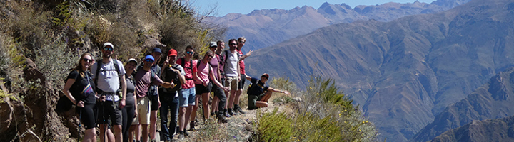 Groep 22-35ers wandelt langs een bergpad met uitzicht op de Andes in Peru.