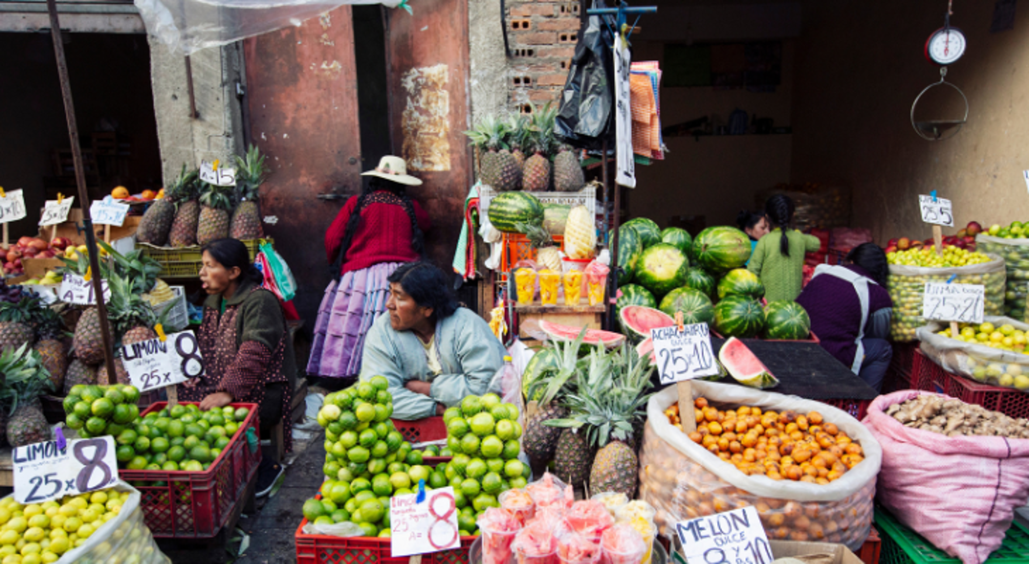 La Paz Fruitmarkt in Bolivia met verkopers en stapels ananas, watermeloenen, limoenen en sinaasappels.