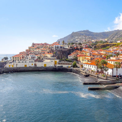 Kustdorp Câmara de Lobos op Madeira met kleurrijke huizen, haven en bergen op de achtergrond.