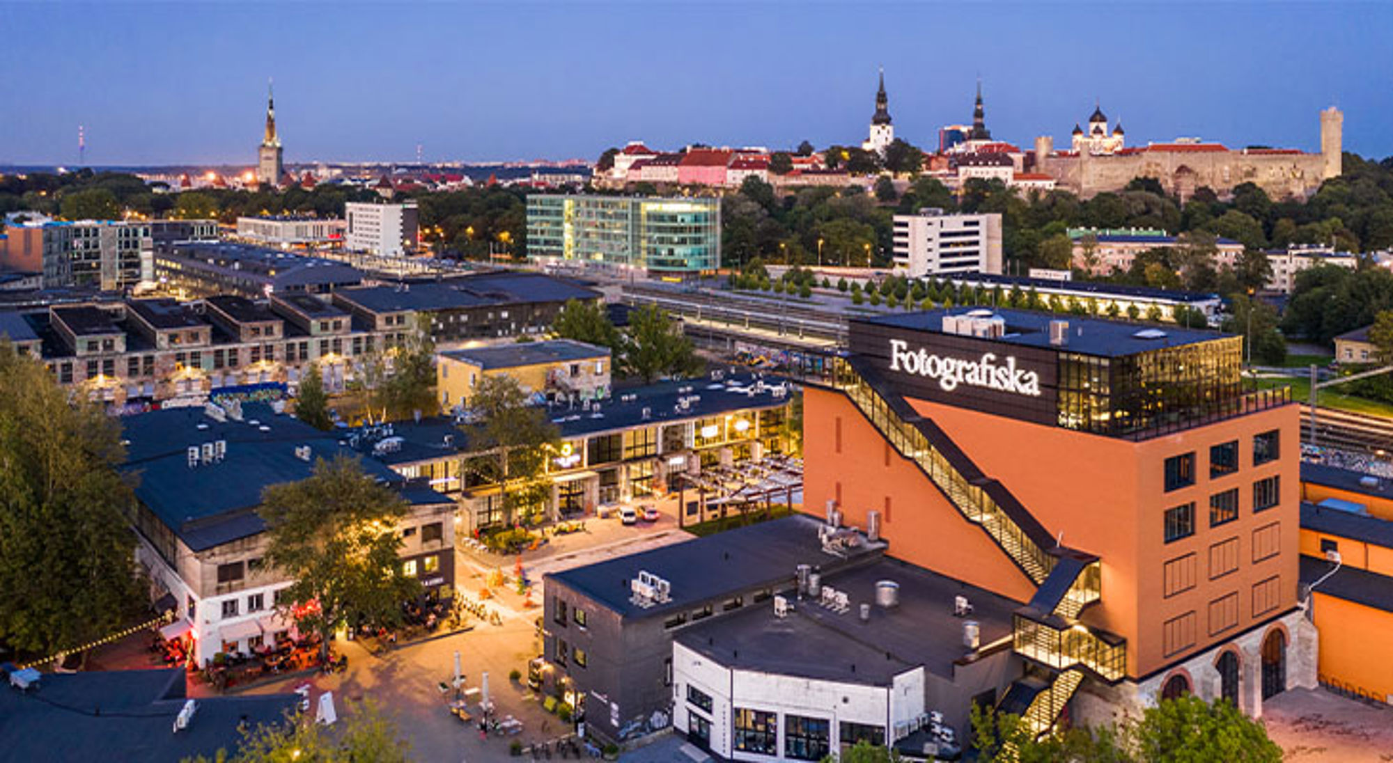 Tellishivi en Old Town Avondzicht op Tallinn met het Fotografiska-gebouw op de voorgrond en de oude binnenstad op de achtergrond.