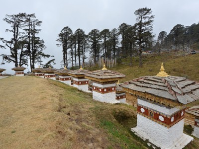 Rij Bhutanese chortens met gebedsvlaggen op een heuvel langs de Route Sikkim en Bhutan.