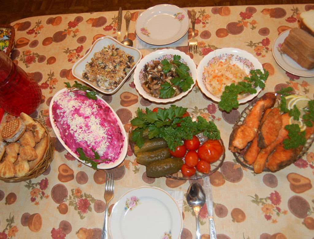 Gedekte tafel met traditionele Russische gerechten, salades, augurken en gebakken vis tijdens groepsrondreis Rusland.