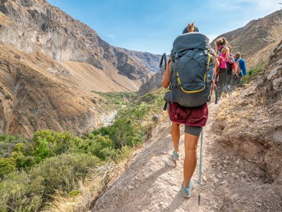 Wandelaars met rugzakken op bergpad in de Colca Canyon, Peru.