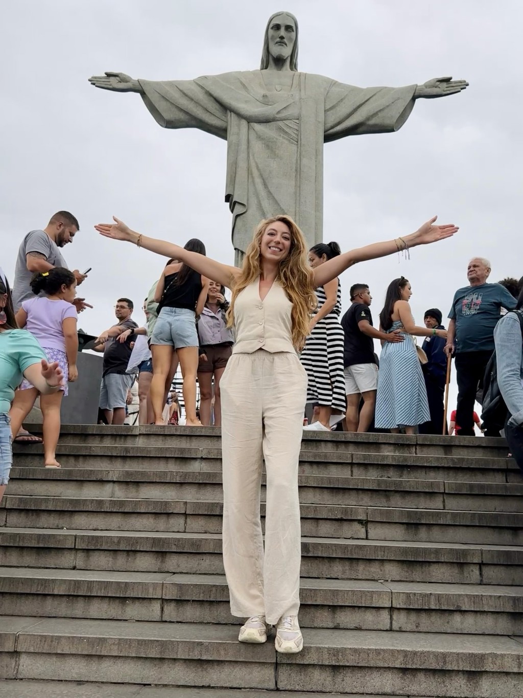 Reiziger poseert met gespreide armen bij Christus de Verlosser in Rio de Janeiro tijdens een 22-35ers reis Brazilië.