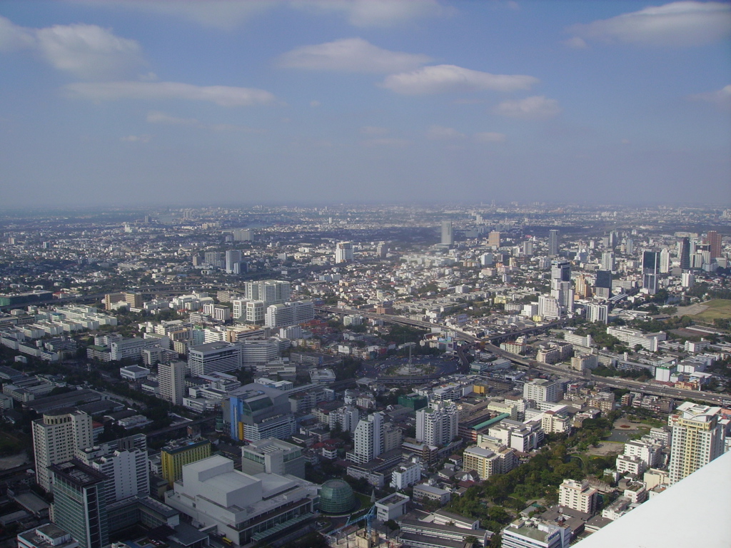 Panorama van Bangkok met wolkenkrabbers en snelwegen, gezien vanaf grote hoogte.