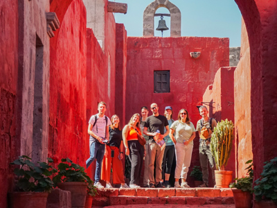 Groep 22-35ers tijdens rondreis Peru in rood kloostercomplex Santa Catalina in Arequipa.