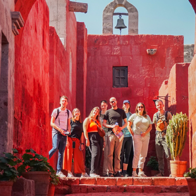 Groep 22-35ers tijdens rondreis Peru in rood kloostercomplex Santa Catalina in Arequipa.
