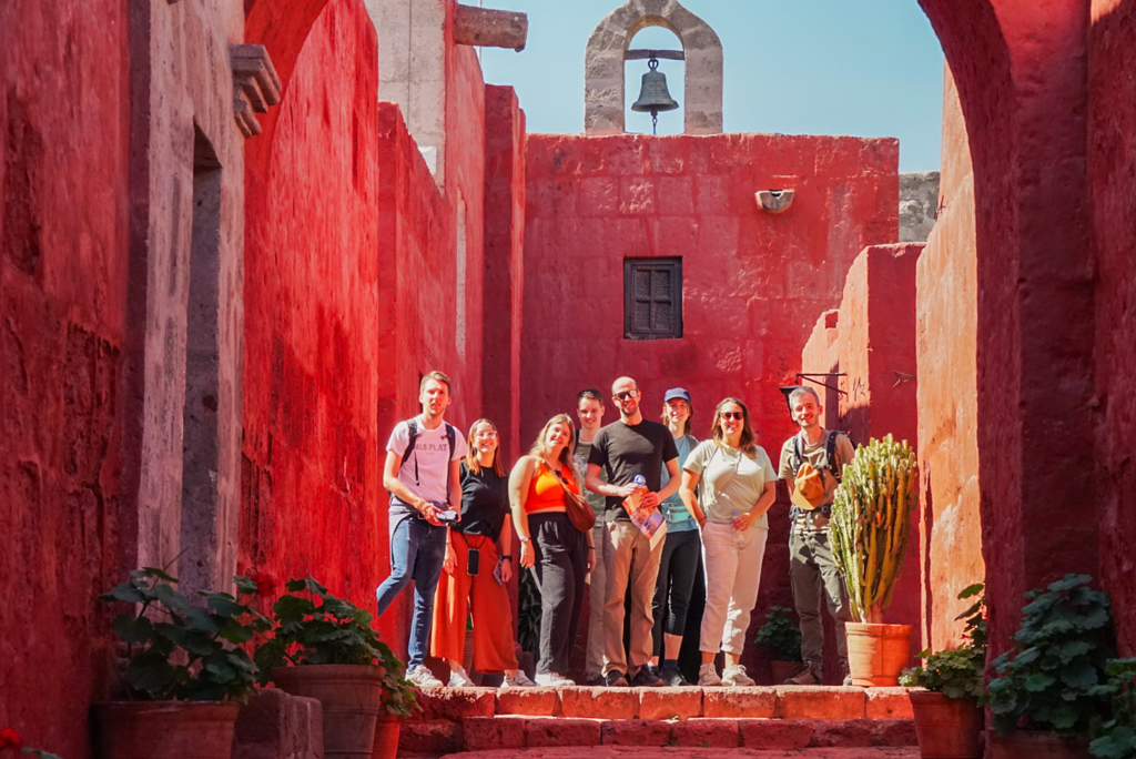 Groep 22-35ers tijdens rondreis Peru in rood kloostercomplex Santa Catalina in Arequipa.