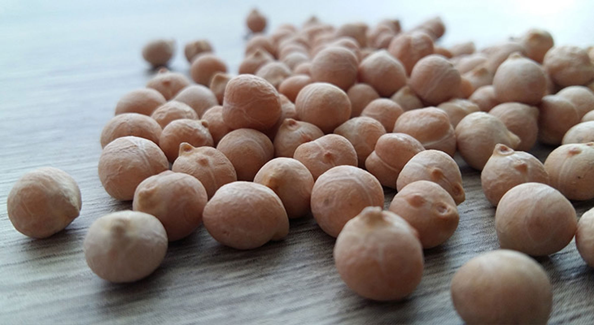 Kikkererwten op een houten tafel, close-up.
