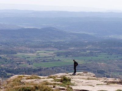 Wandelaar op een rotsplateau met uitzicht over de bergen en valleien van Aragón, Spanje.