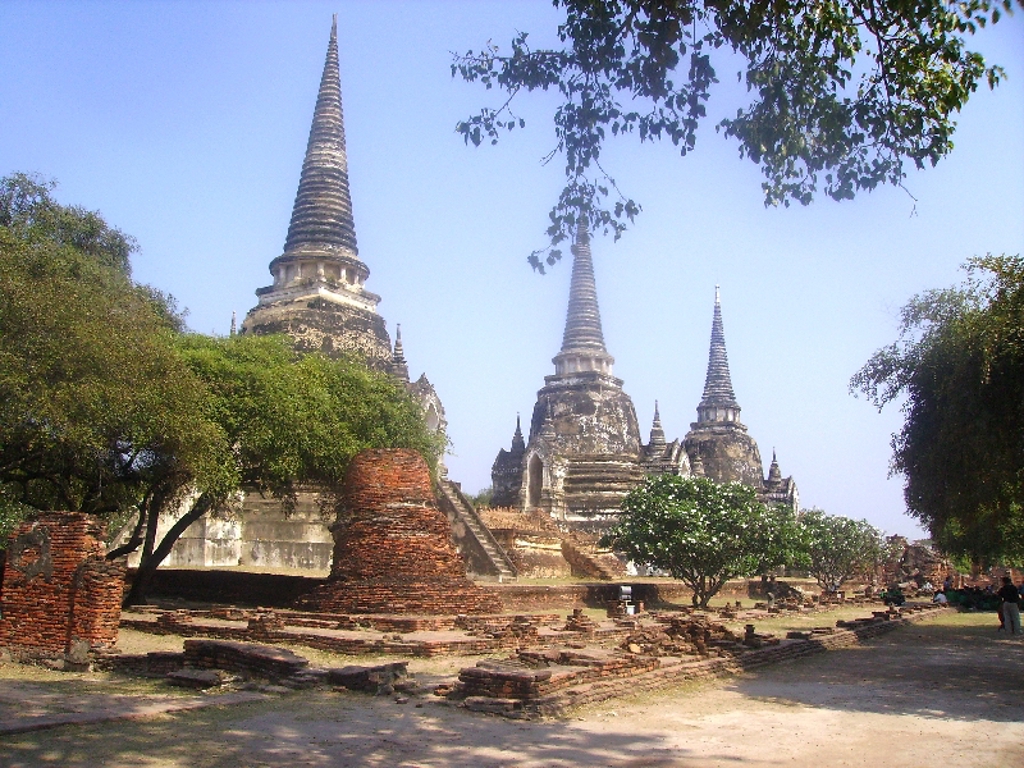 Groepsrondreis Thailand: reiziger in boeddhistische tempel met gouden beelden.