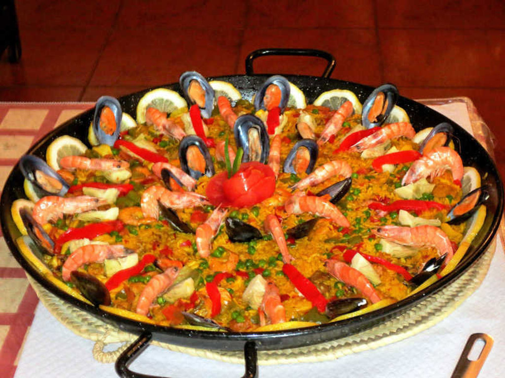 Paella met garnalen, mosselen en citroen, typisch Spaans gerecht tijdens familiereis Spanje & Portugal.