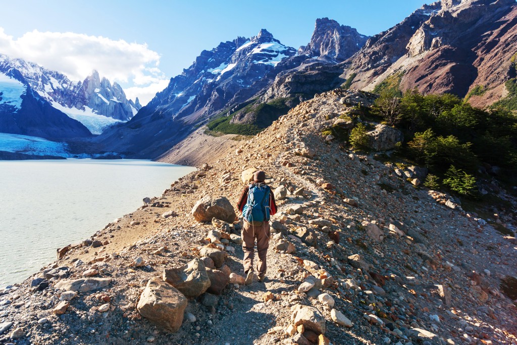 Wandelaar langs een bergmeer met gletsjer en ruige bergtoppen in Patagonië, Argentinië.