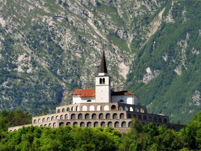 Kerk van Javorca in de Soča-vallei, Slovenië, met bergen op de achtergrond.