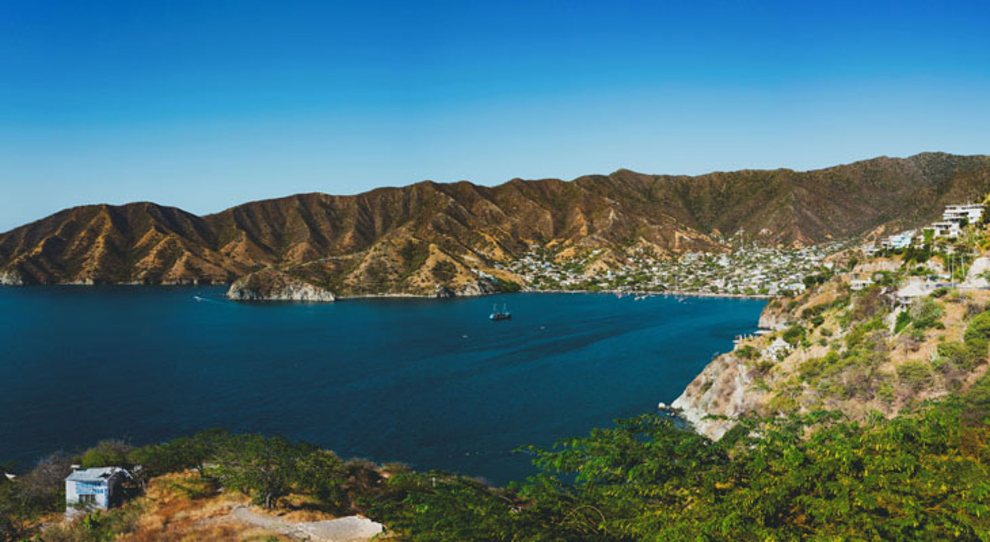 Panoramisch uitzicht op de baai van Santa Marta met bergen, blauwe zee en kustplaats in Colombia.