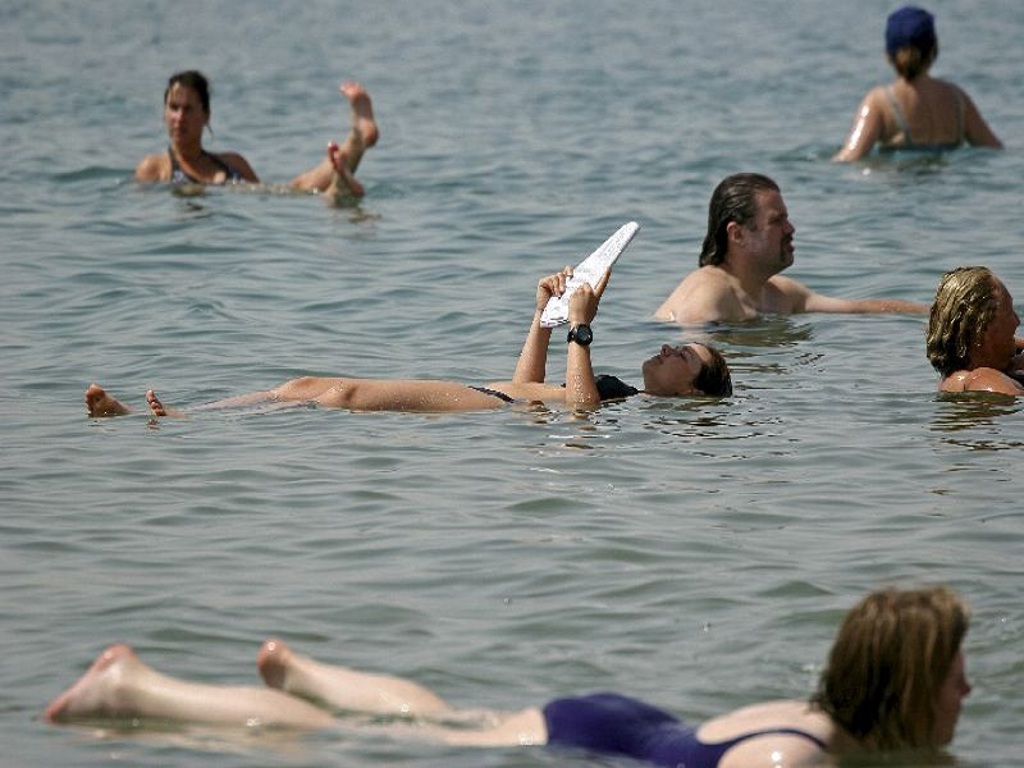 Reizigers drijven in de Dode Zee in Jordanië tijdens een familiereis.